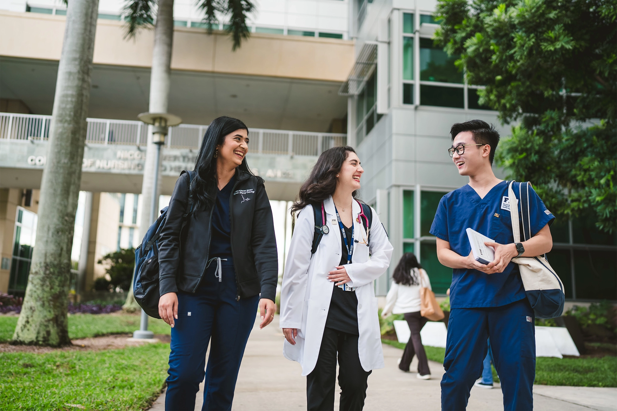 three nurseing students walking, laughing and talking