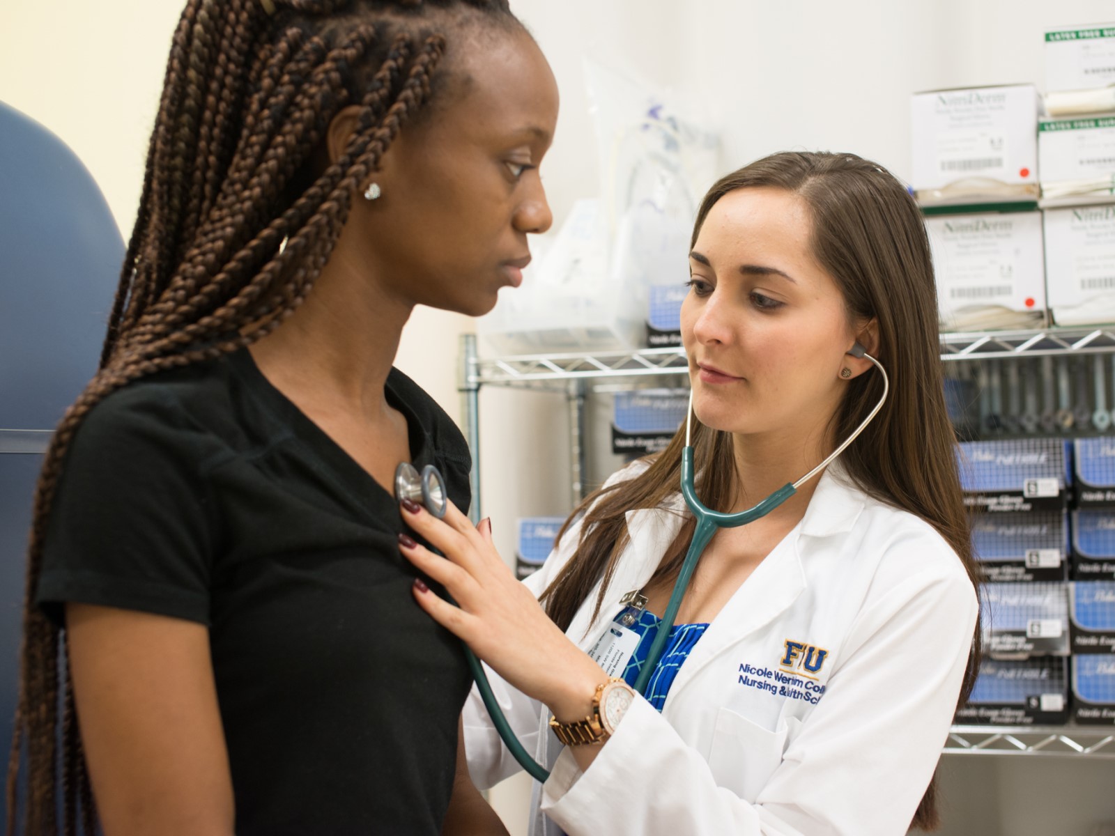 Image of FIU nursing student listening on stethoscope